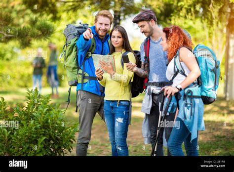 Los jóvenes excursionistas mirar el mapa y brújula para orientarse en