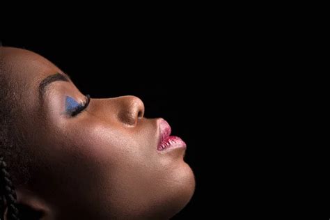 Side View Portrait Of Dark Skinned Model On A Black Background Stock