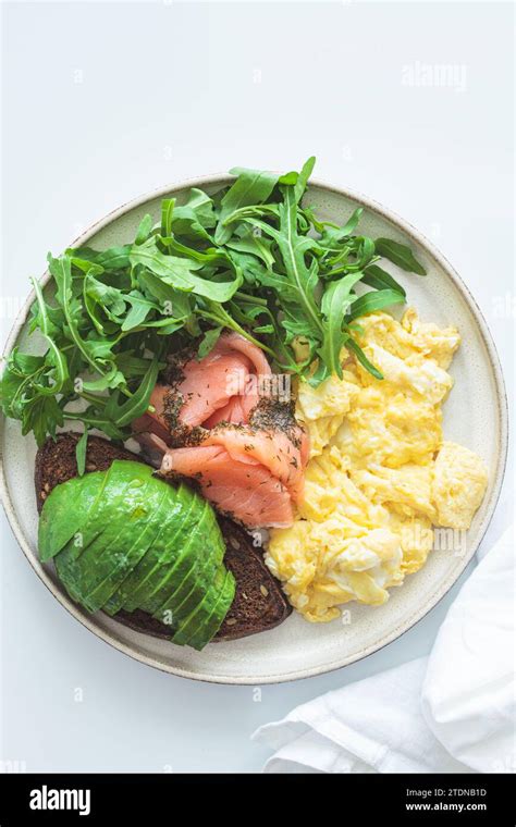 Keto Breakfast Avocado Toast Smoked Salmon Scrambled Eggs And Arugula White Background Top