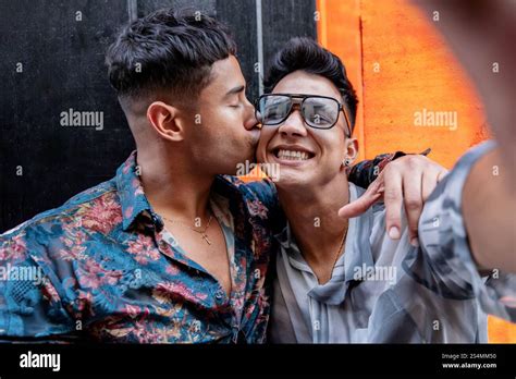 Latin Gay Couple Taking Selfie While Embracing Warmly One Partner Kisses The Other S Cheek