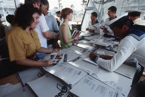 A Crewman Autographs A Pamphlet For A Norfolk Resident Touring The