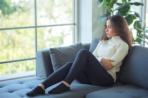 El estilo de vida relaja a la mujer latina feliz que se relaja en el sofá en casa Foto Premium