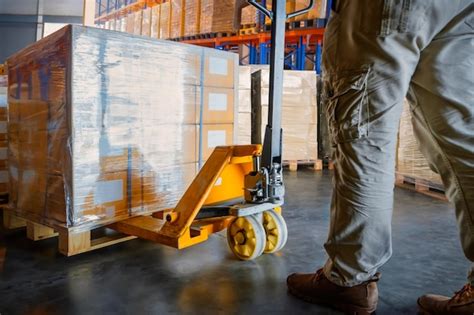 Premium Photo Workers Unloading Package Boxes On Pallets In Warehouse