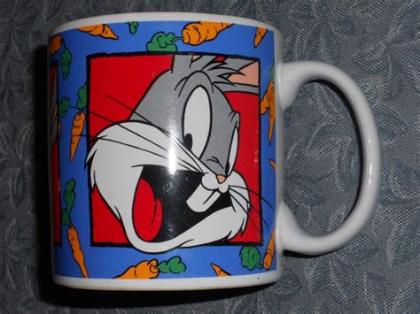 A Coffee Mug With An Image Of Bugs And Carrots Painted On It S Side