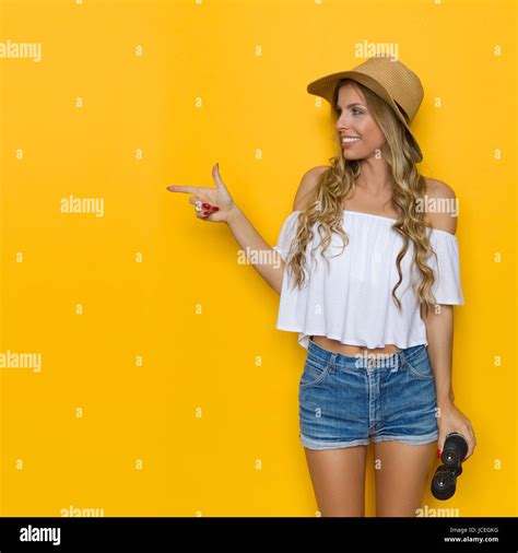 Blond Young Woman In Jeans Shorts White Shirt And Straw Hat Holding