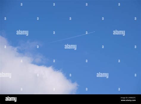 Distant Passenger Jet Plane Flying On High Altitude On Blue Sky With