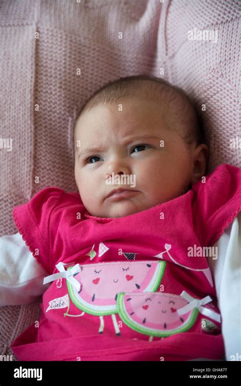 Grumpy face newborn baby in watermelon top Stock Photo - Alamy