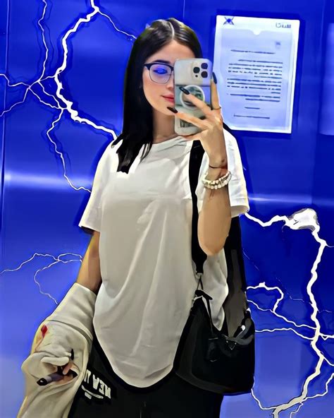 A Woman Taking A Selfie In Front Of A Blue Wall With Lightning Streaks