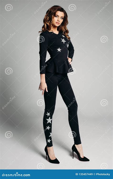 Gorgeous Woman in Black Suit with Silver Stars and Black Heels Posing ...