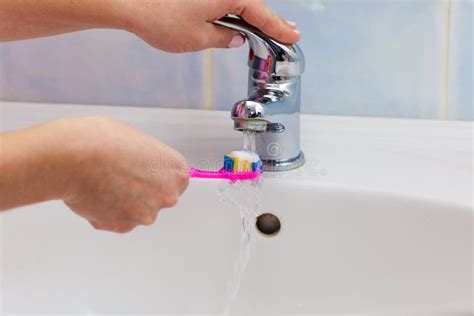 Hand Holding Toothbrush In Bathroom Stock Photo Image Of Faucet