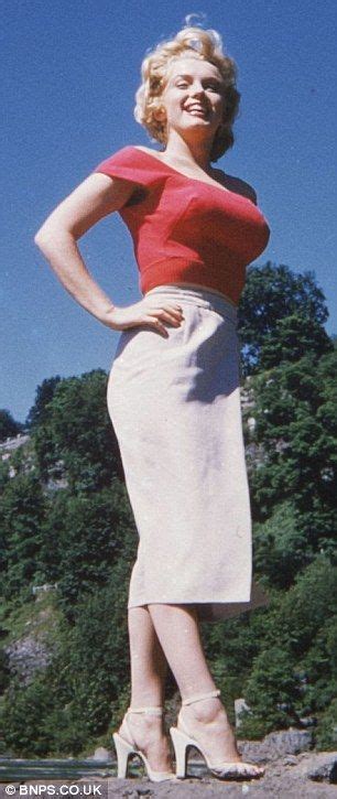 A Woman In A Red Top And White Skirt Posing For The Camera With Her