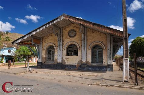 An Old Run Down Train Station On The Side Of A Road With People Walking By