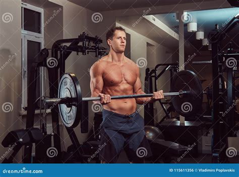 Muscular Shirtless Bodybuilder Male Lifting A Barbell On A Biceps In A