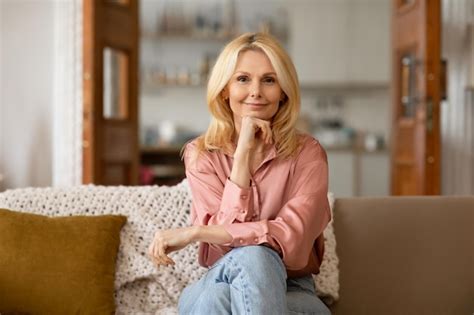 Premium Photo Happy Mature Blonde Woman Posing Sitting On Sofa At Home