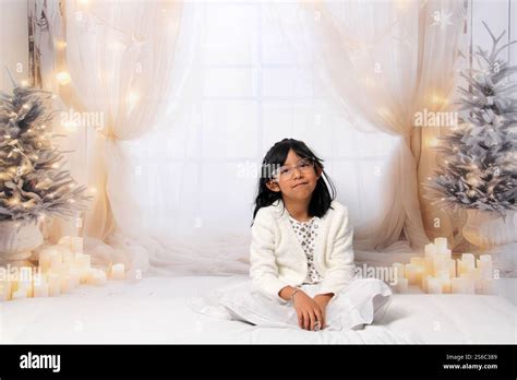 5 Year Old Latina Brunette Girl With Eyeglasses Among Decorated Trees Is Excited To Celebrate