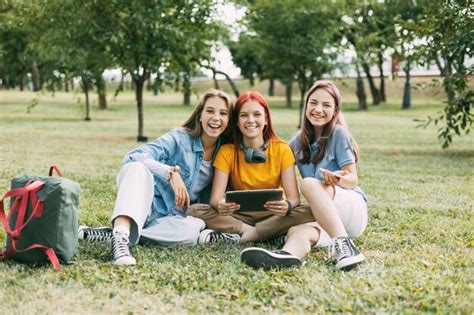 Premium Photo Portrait Of A Smiling Young Woman Sitting On Grass