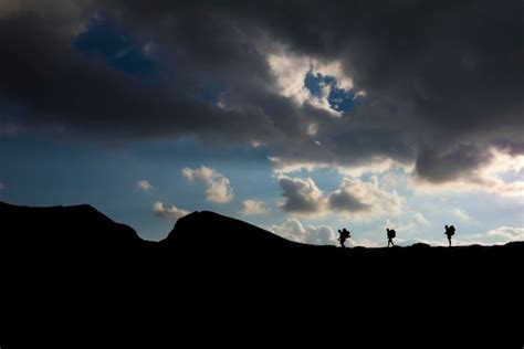 Premium Photo Silhouette Of Hikers With Backpacks Climbing The Mountain