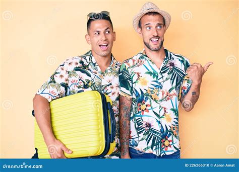 Joven Pareja Gay De Dos Hombres Sosteniendo Una Maleta Yendo De Vacaciones De Verano Apuntando