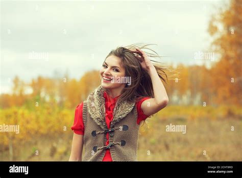 Autumn Portrait Of A Beautiful Brunette Middle Aged Woman In A Red