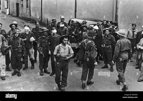 Ww2 German Prisoners Of War Are Blindfolded And Escorted Through The Streets After Commandos