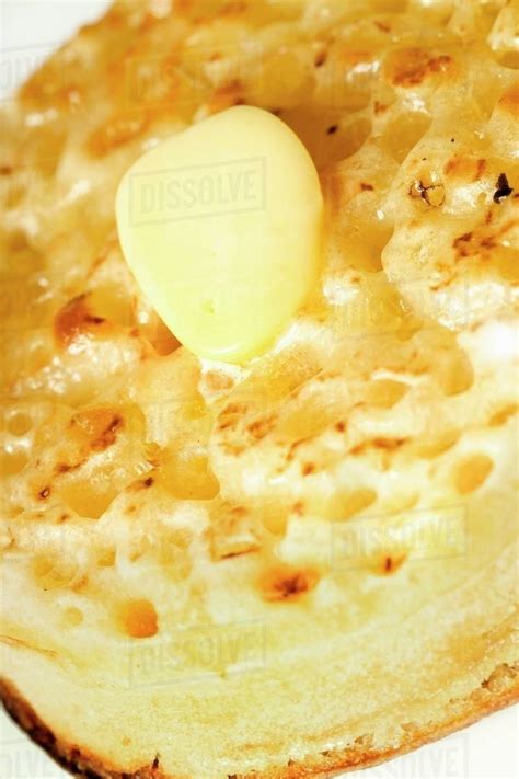 Toasted crumpet with butter - Stock Photo - Dissolve