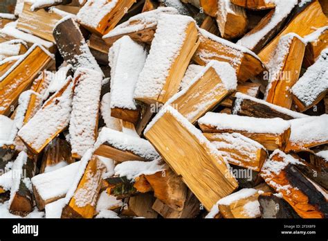 Stacked Firewood Covered With Snow A Woodpile Of Dry Fire Woods In The