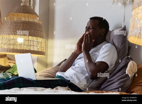 Tired African Man Yawning At Home At Bed Stock Photo Alamy