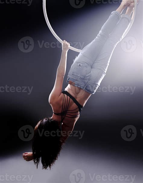 A female Aerial hoop gymnast performing exercises on an Aerial hoop ...