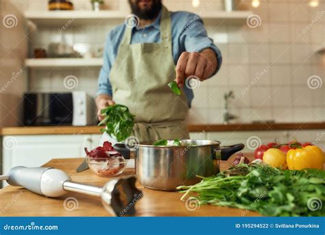 Toma Recortada Del Hombre Cocinero Que Agrega Hoja De Albahaca A La