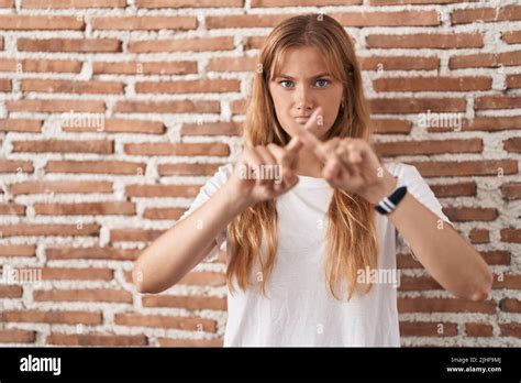 Young Caucasian Woman Standing Over Bricks Wall Rejection Expression