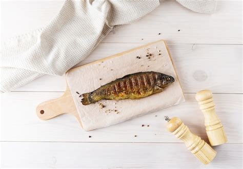 Premium Photo Trout Fish Stuffed With Lemon And Spices On A Wooden Board