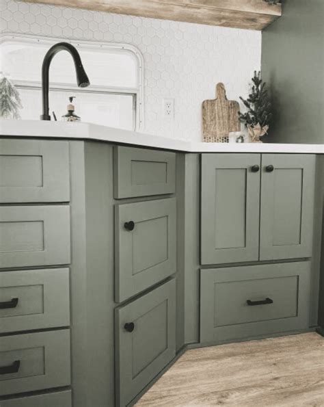 A Kitchen With Green Cabinets And White Counter Tops