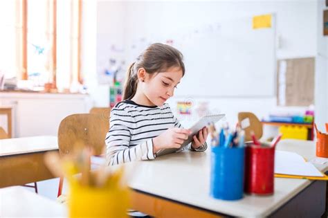 Retrato De Una Colegiala Linda Sentada En El Escritorio Usando Tablet