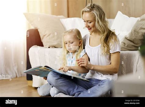 Bonne Famille Une Jeune M Re Blonde Lit Un Livre Sa Jolie Fille Tout En Tant Assise Au Sol