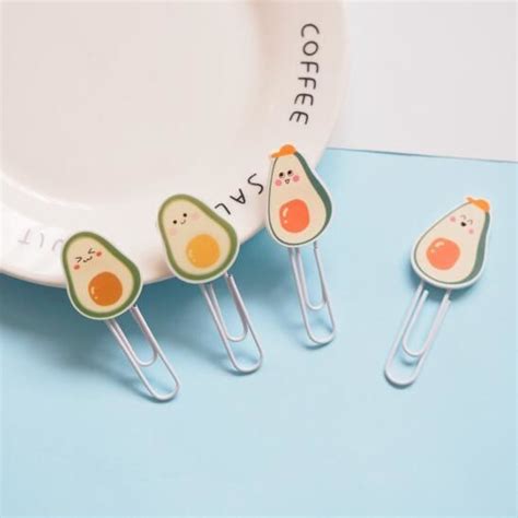 Three Avocado Shaped Pins Sitting On Top Of A Blue Table Next To A