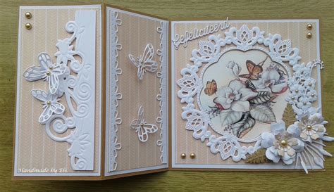 An Open Card With White Flowers And Butterflies On The Front Sitting