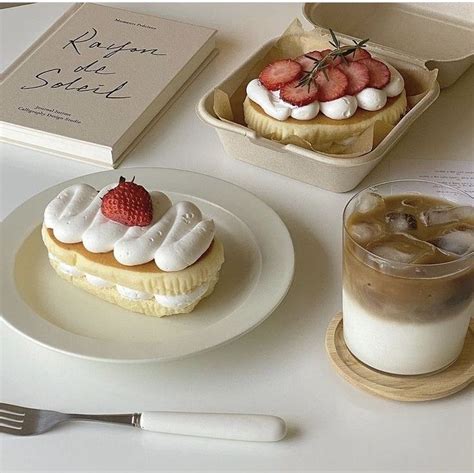 A Table Topped With Two Desserts And A Cup Of Coffee Next To A Book