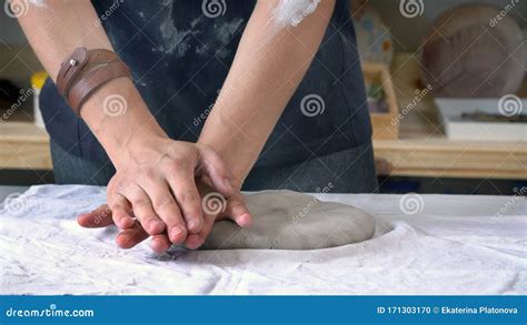 Female Sculptor`s Hands Are Kneading Clay For A Ceramic Plate Stock