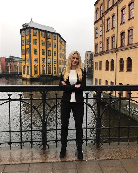 A Woman Standing Next To A Railing In Front Of A Body Of Water With