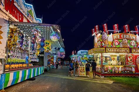 Nighttime at carnival county fair with vendors of games and food Stock ...