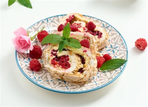 Premium Photo Baked Meringue Roll With Cream And Fresh Red Raspberry