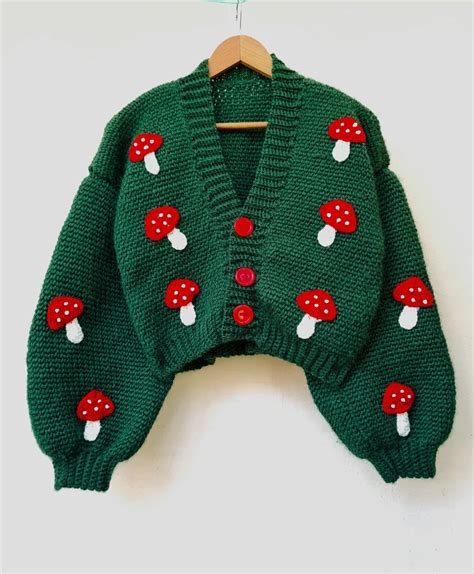 A Green Sweater With Red Mushrooms On It