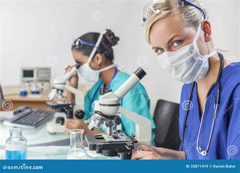 Female Scientific Research Team Using Microscopes In Laboratory Stock