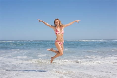 Feliz Mujer Fit En Bikini Saltando En La Playa Foto Premium