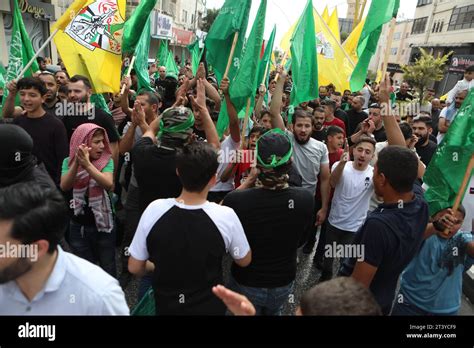 Palestinos ondean banderas de Hamás y Fateh mientras participan en una