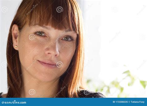 Portrait Of Woman Looking At Camera With Soft Smile And Look Stock