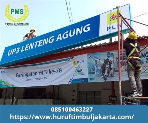 Two Men Working On The Side Of A Building With Banners Above It And