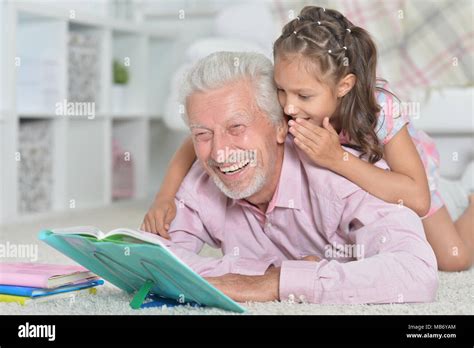 Grandfather Reading Book With His Granddaughter Stock Photo Alamy