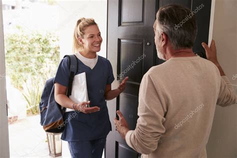 Hombre Mayor Abriendo Su Puerta Principal A Una Trabajadora De La Salud