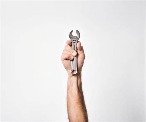 Premium Photo Hand Holding A Wrench On A White Background Labor Day Concept